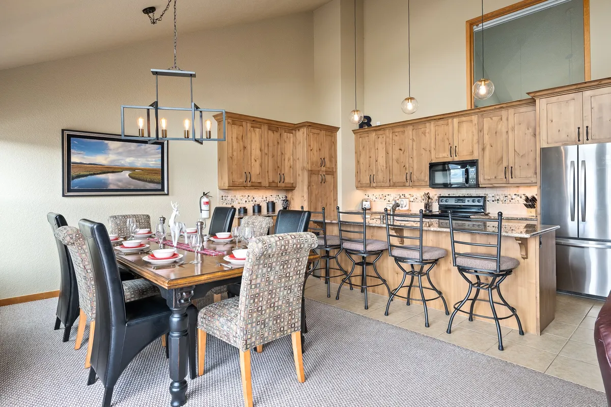 A spacious, inviting dining and kitchen area with a stylish table, kitchen island, and art on the wall. The setting suggests an ideal space for family dinners, social gatherings, or enjoying a meal prepared by a private chef, with a cozy and communal ambiance.