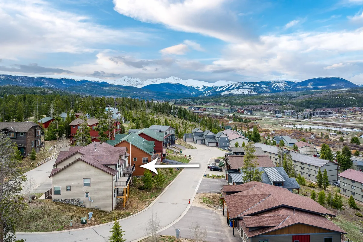 This neighborhood view highlights a mountain backdrop, nearby homes, and the roadway leading into trails and scenic open space. It evokes the adventure possibilities just outside the villa—from hiking and biking to dog walks with panoramic views.